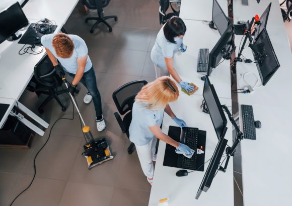 Top view. Group of workers clean modern office together at daytime Kontorsstädning
