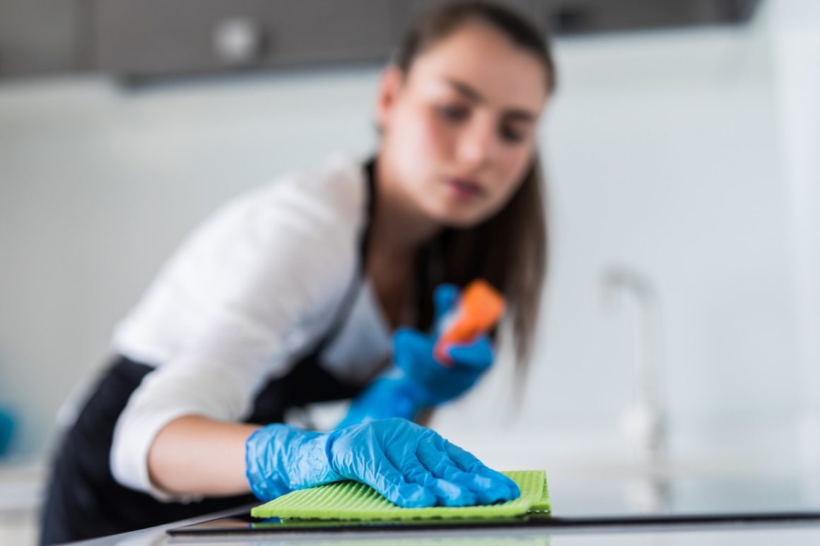 young smiling woman cleans the kitchen at home